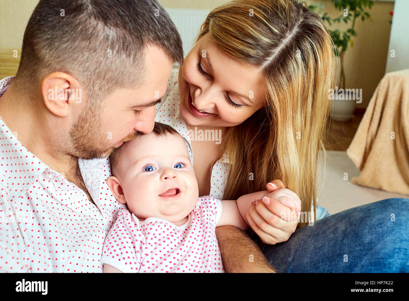 A happy family. Mom and Dad with baby in the room Stock Photo - Alamy