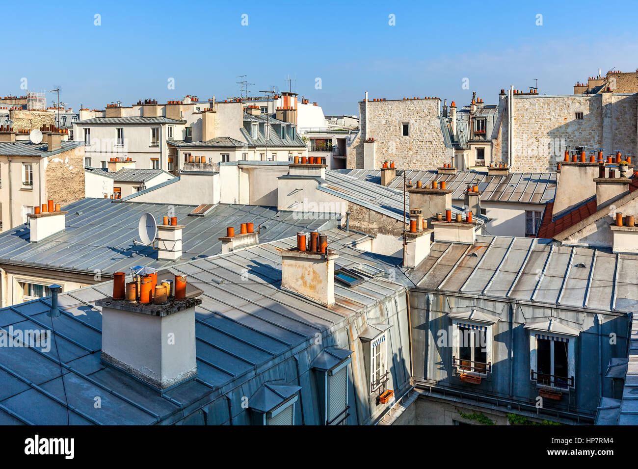 View of typical parisian roofs with mansards and chimneys in Paris, France. Stock Photo