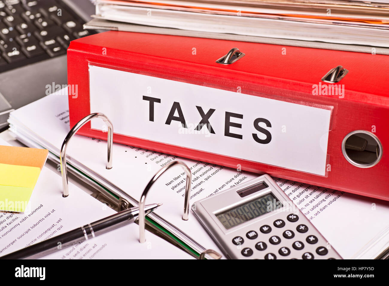 Red file folder with the label taxes, calculator and correspondence