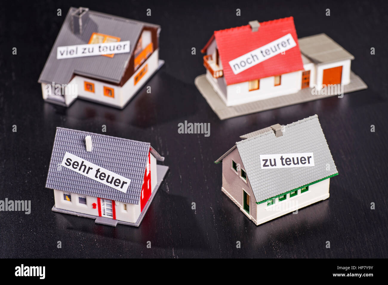 Houses with labels that symbolize overpricing. Stock Photo