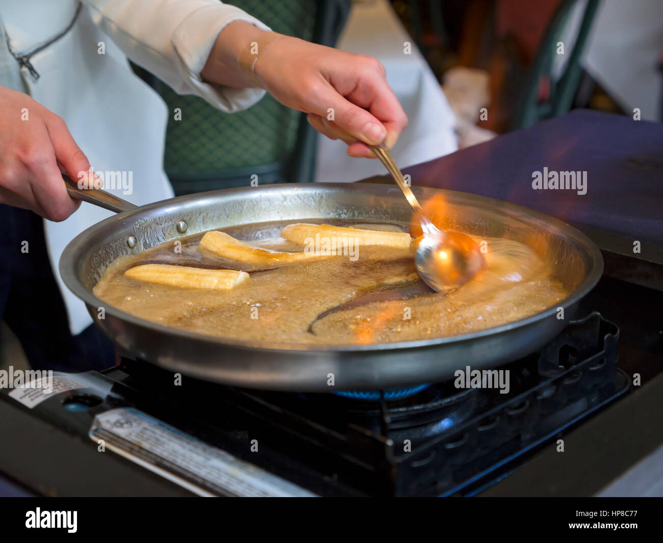 Bananas Foster being prepared at the table in a restaurant Stock Photo
