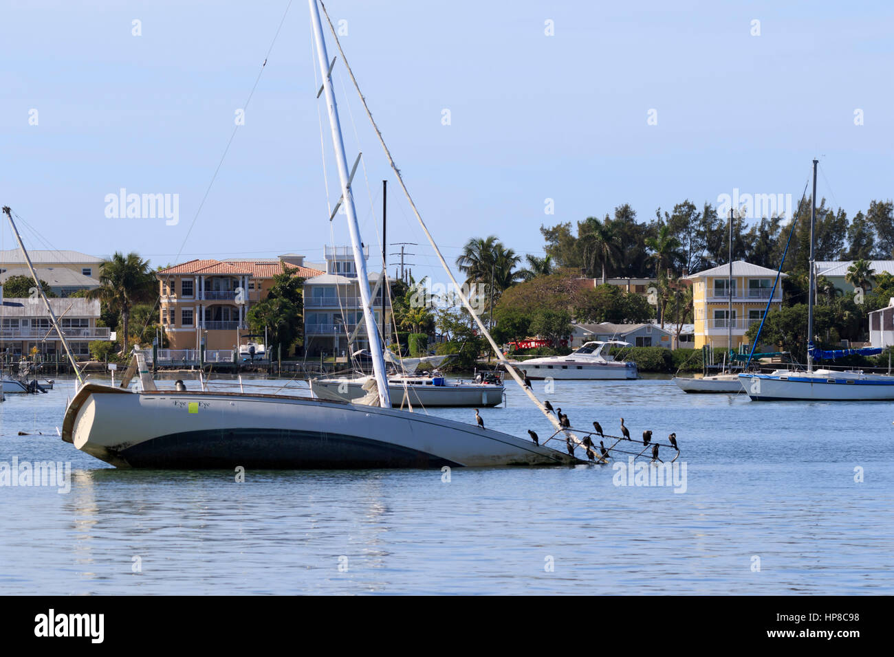 Derelict sailboat in Florida waterway. A half sunk sailing yacht has