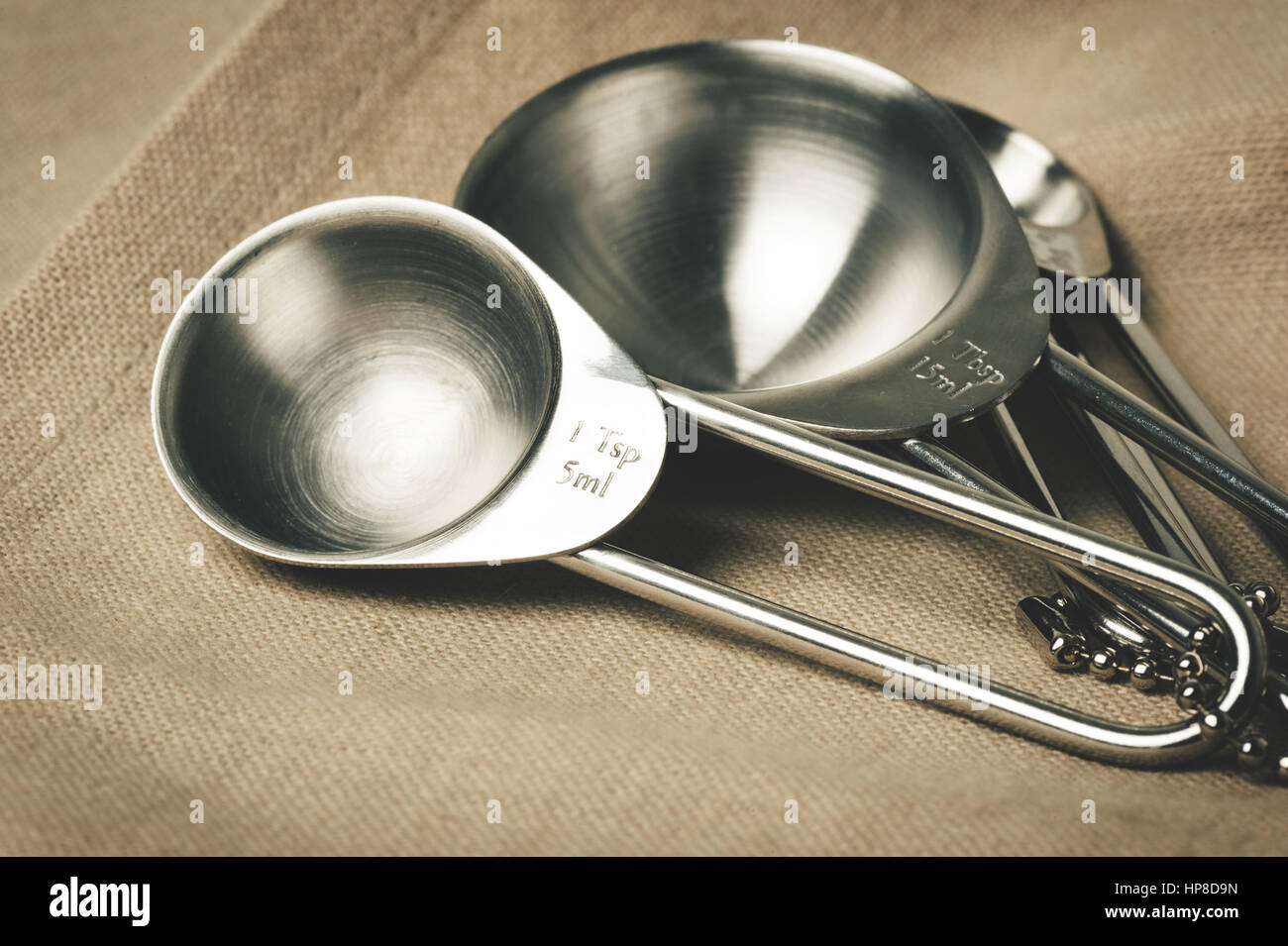 set of stainless steel measuring spoons in varying sizes Stock Photo