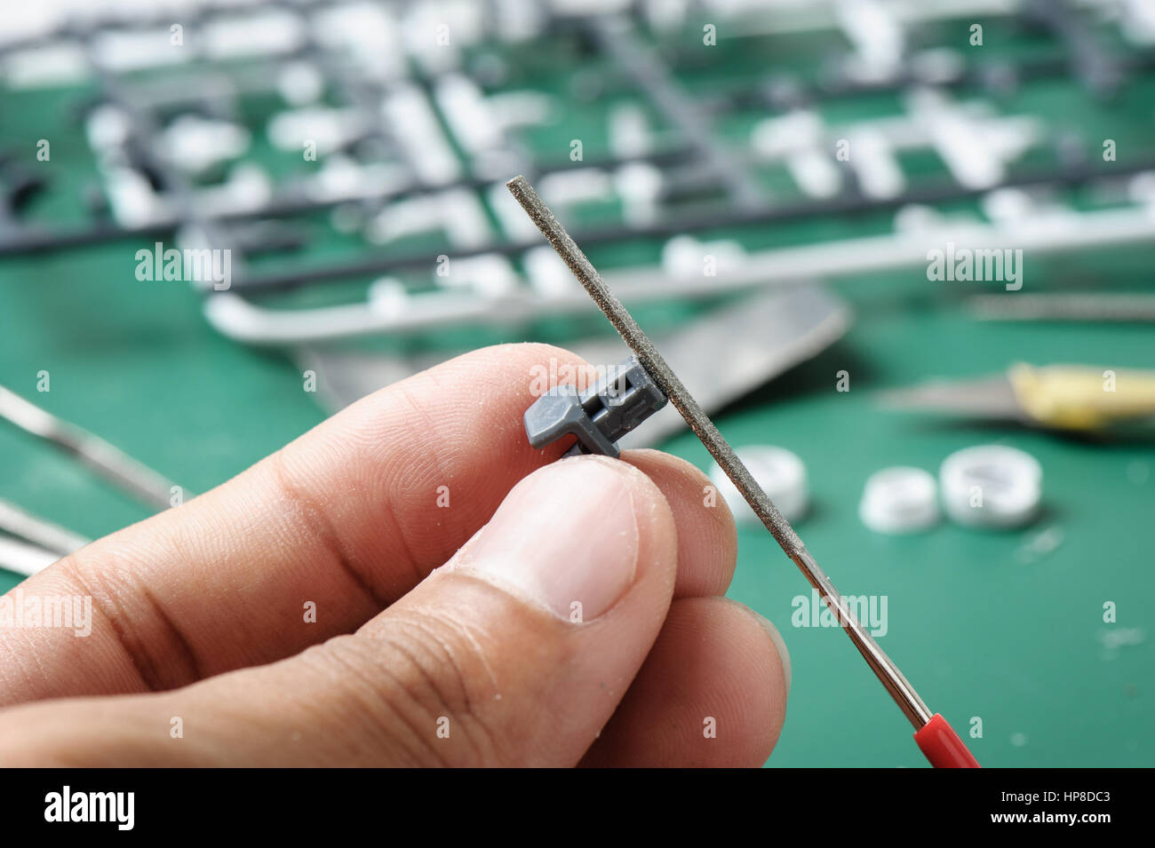 closeup a man's hand sanding a plastic model with rasp Stock Photo Alamy