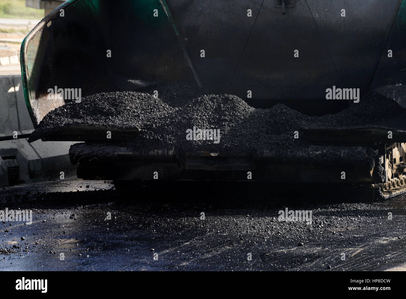 closeup hot asphalt in the hopper of asphalt paver machine Stock Photo