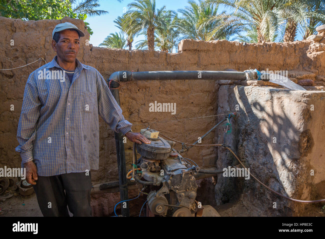 Draa River Valley, Morocco.  Berber Farmer with Motorized Pump Drawing Water from Underground Aquifer. Stock Photo