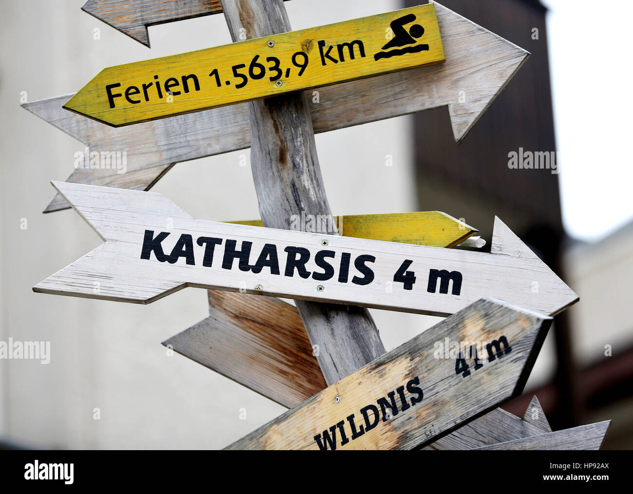 Leipzig, Germany. 20th Feb, 2017. A roadsign points towards 'Holidays' (1563, 9 km), catharsis (4 m) and Wilderness (41 m) in front of the 'Theater der Jungen Welt' in Leipzig, Germany, 20 February 2017. According to Aristoteles the spectator of the tragedy traverses through the feelings of lamentation and horror to the catharsis of the soul. The sign is inviting people to experience the process at the 'Theater der Jungen Welt'. Photo: Jan Woitas/dpa-Zentralbild/dpa/Alamy Live News Stock Photo