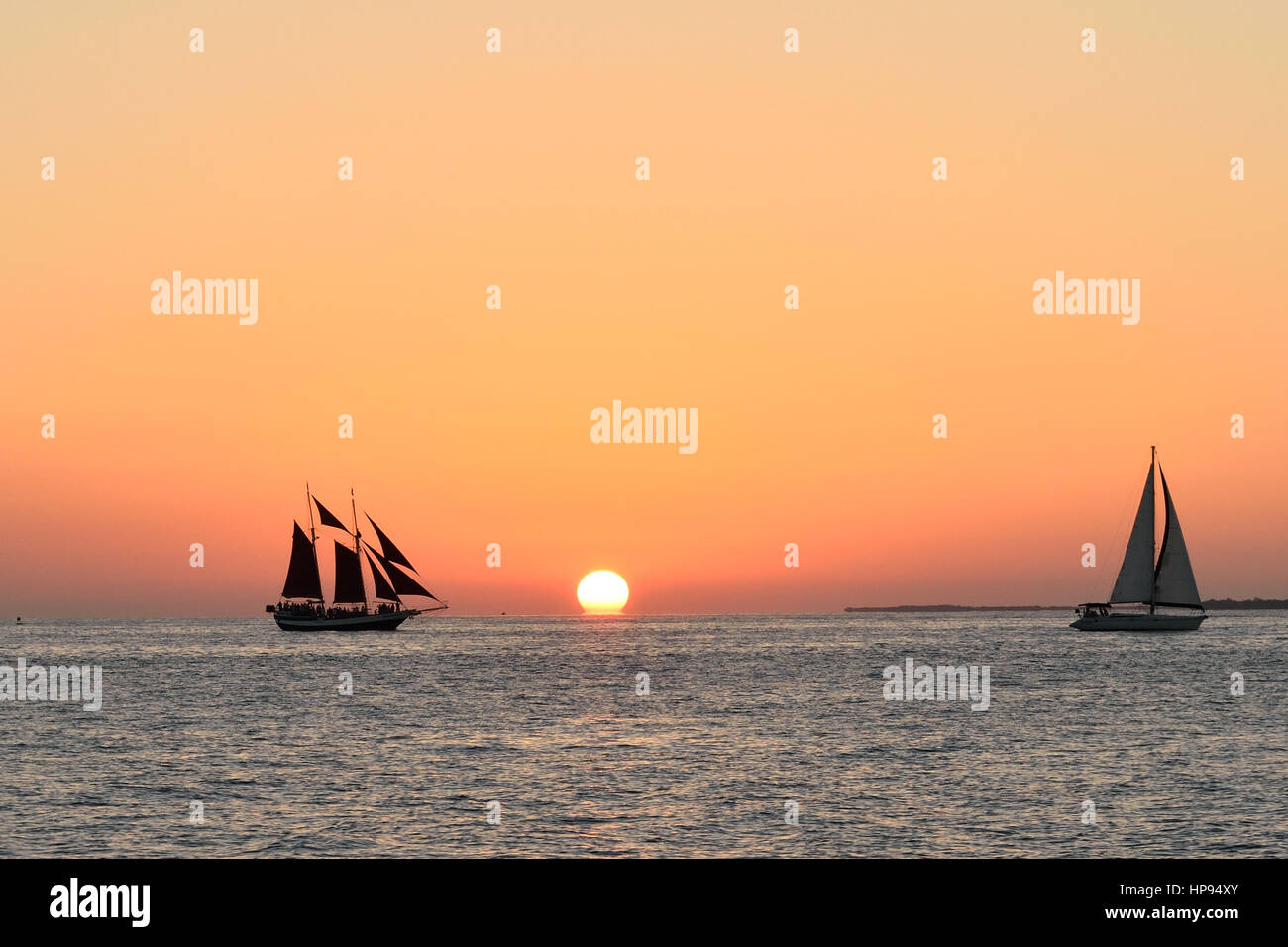 Sailboats in front of a beautiful Key West sunset. Taken from Malory Square Stock Photo