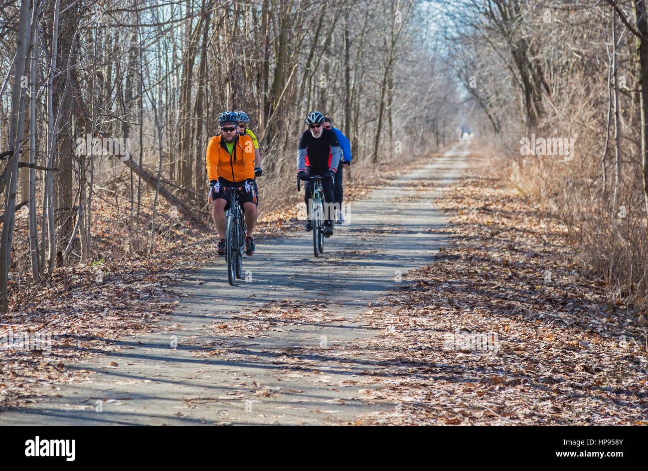 Armada, Michigan - Bicycle riders on the Macomb Orchard Trail on a mid-February day of record warmth (66F). The popular 23.5-mile trail was built on t Stock Photo