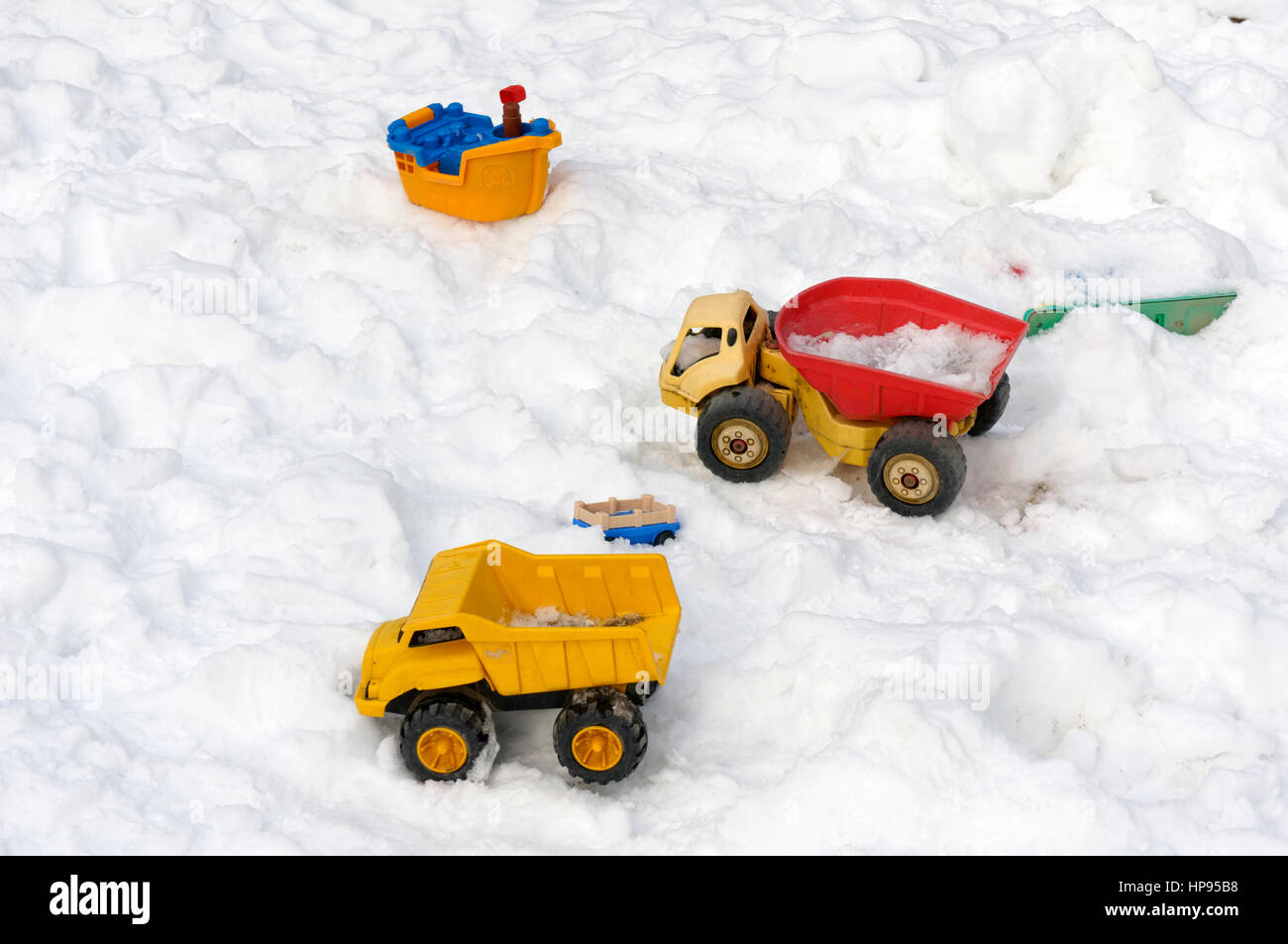 Children's plastic toys abandoned in the snow Stock Photo