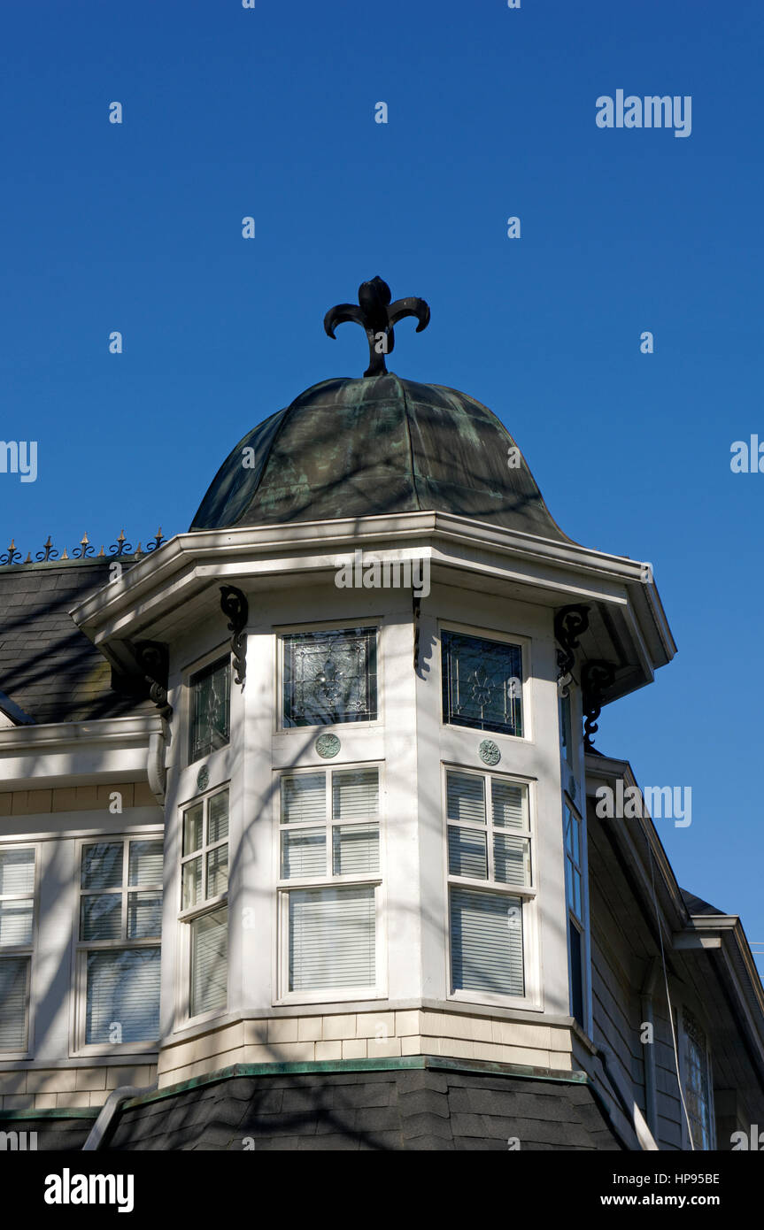 Close-up of an ornate cupola with French fleur-de-lis finial on a Queen Anne Revival style house in Vancouver, British Columbia, Canada Stock Photo