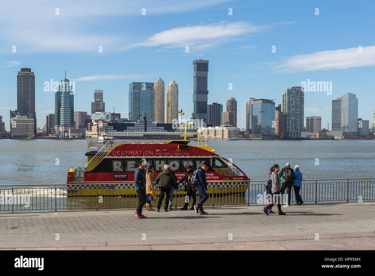 A NY Waterway ferry arrives at the World Financial Center Ferry Terminal, with the skyline of Jersey City in the background across the Hudson River. Stock Photo