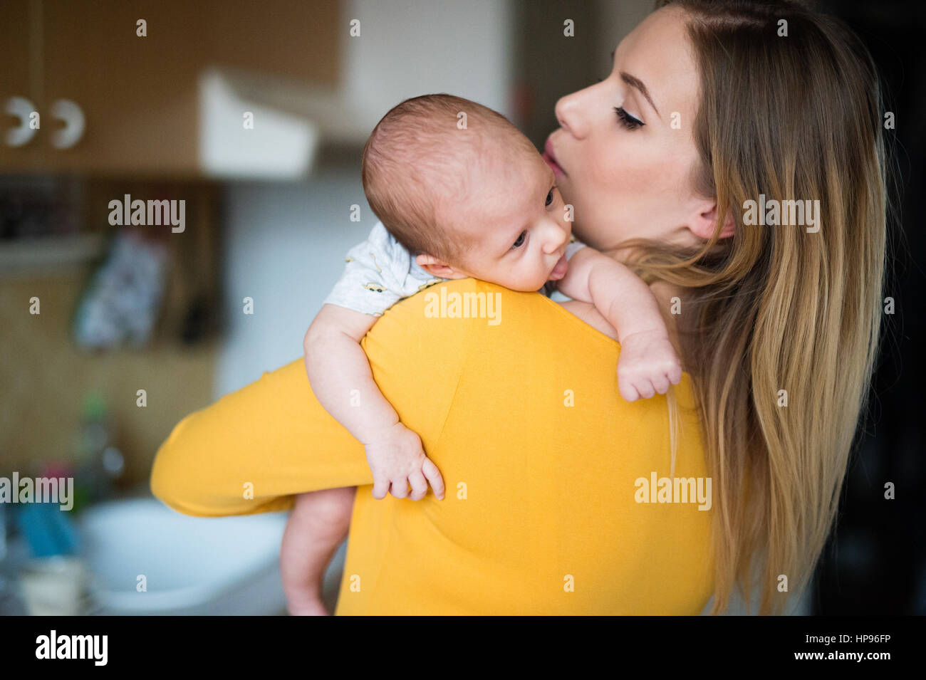 Beautiful young mother holding baby son in her arms Stock Photo - Alamy
