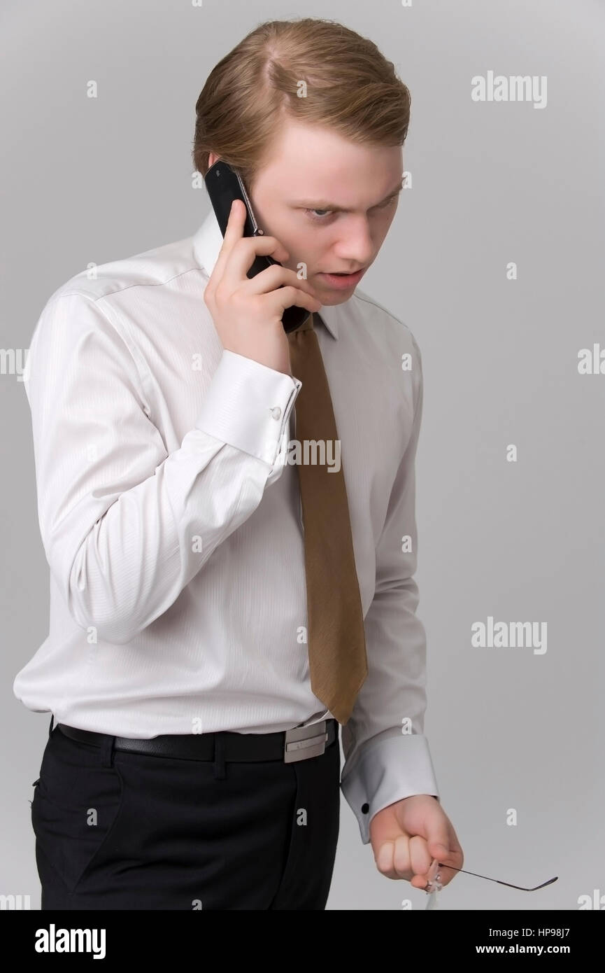 Model released , Zorniger, junger Gesch?ftsmann mit Handy - young businessman with mobile phone Stock Photo
