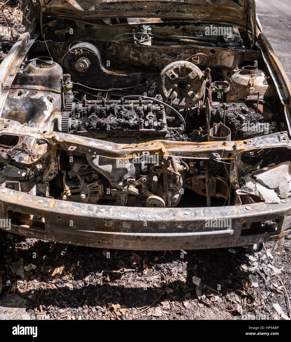 Burnt out car wreck after a fire in the forest road. Burnt out