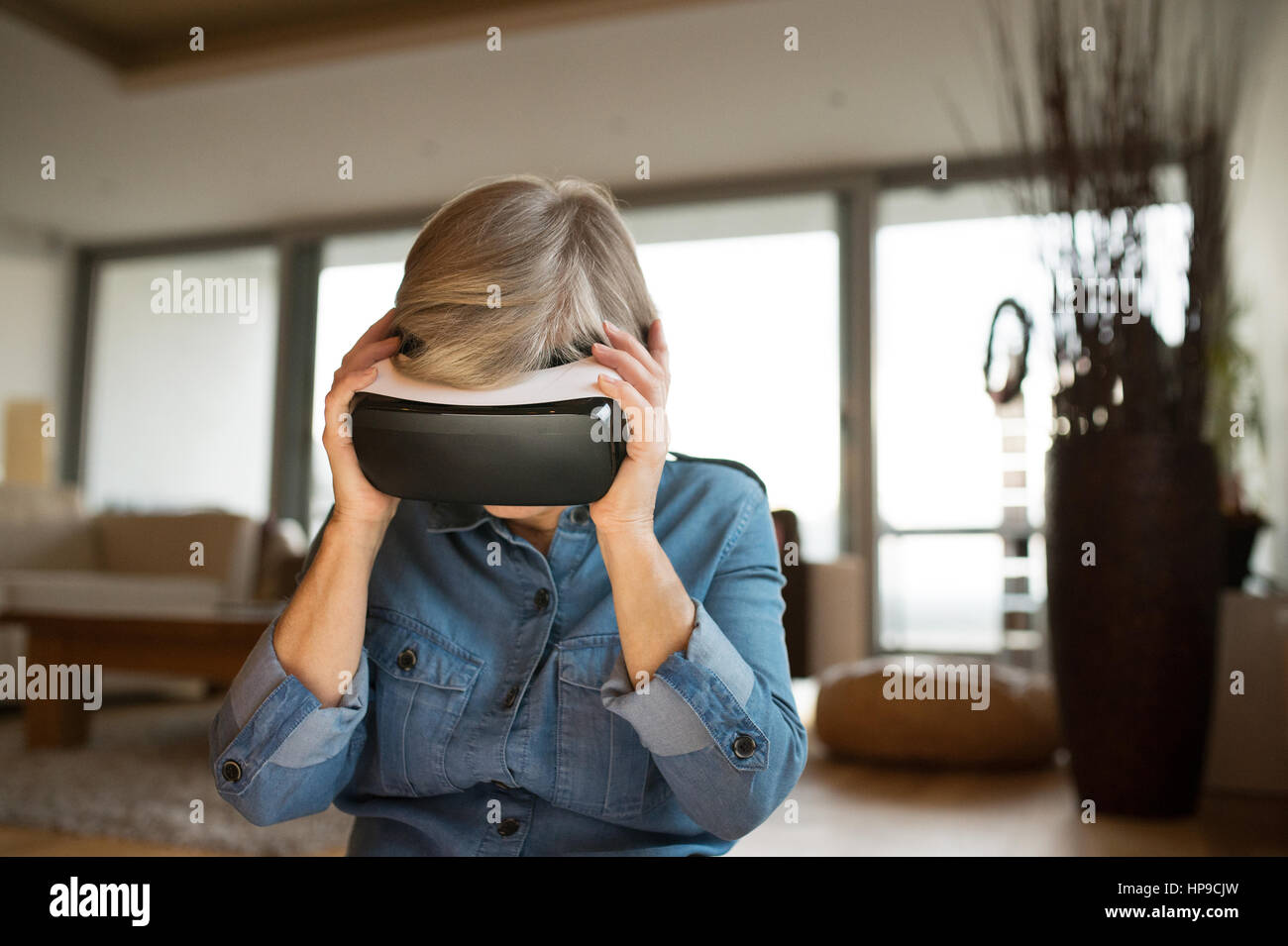 Senior woman wearing virtual reality goggles at home Stock Photo - Alamy