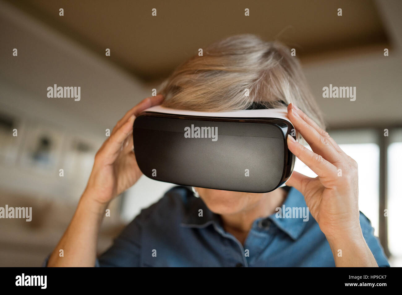 Senior woman wearing virtual reality goggles at home Stock Photo Alamy