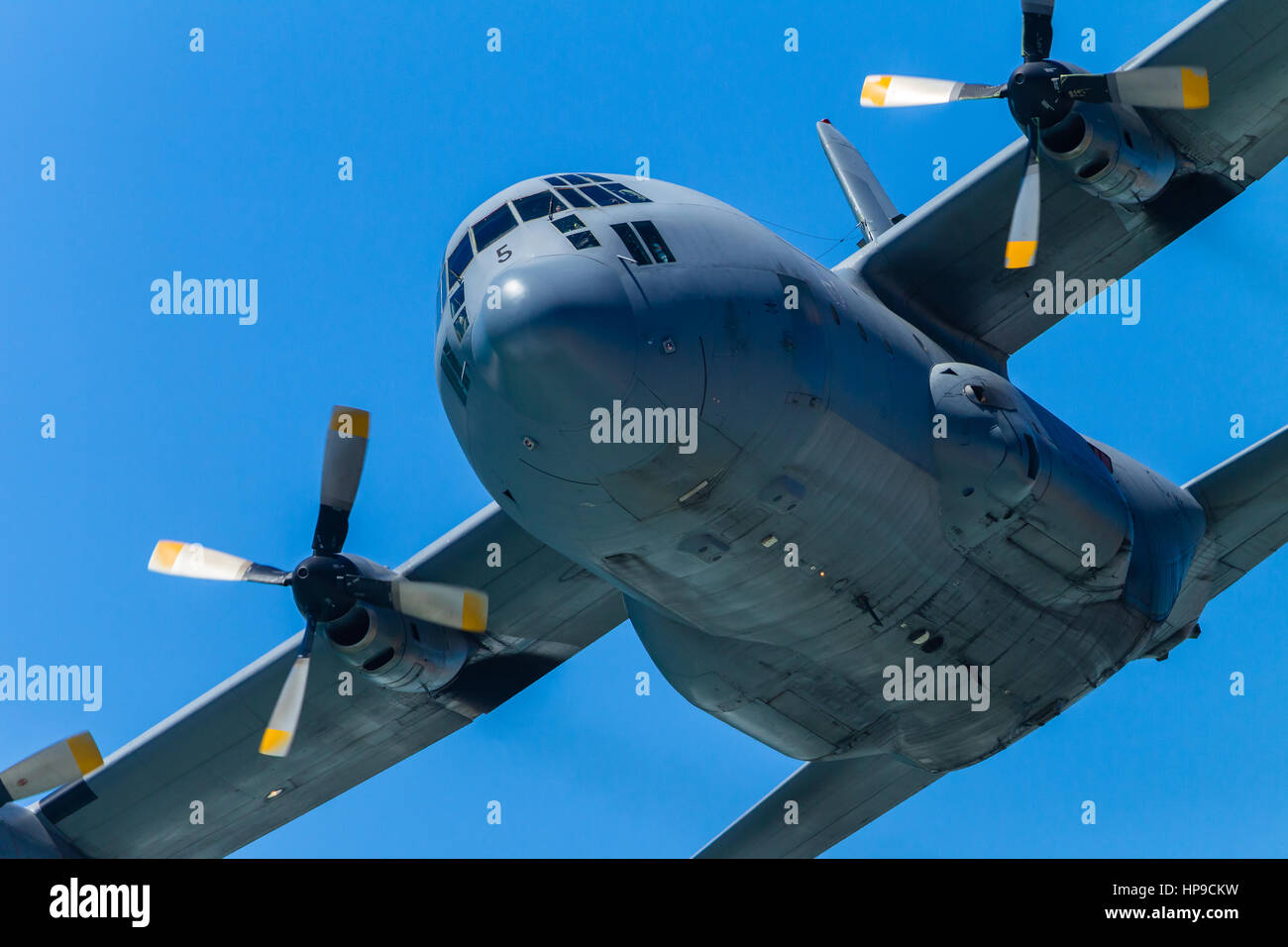 Military aircraft  four engine propellor plane flying low pass closeup summers day. Stock Photo