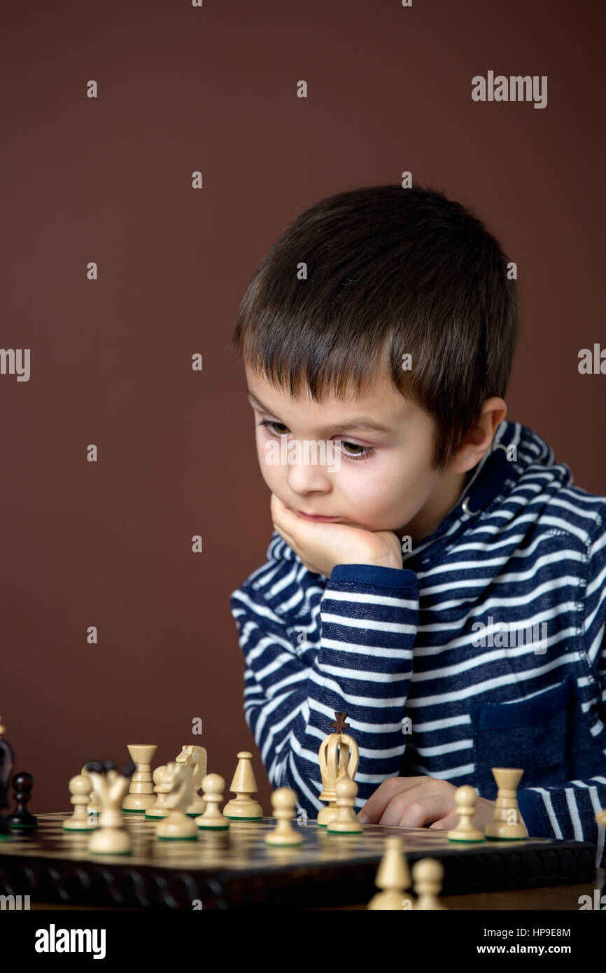 Little boy, playing chess. Smart kid, isolated, playing chess. Children playing intelligent game Stock Photo