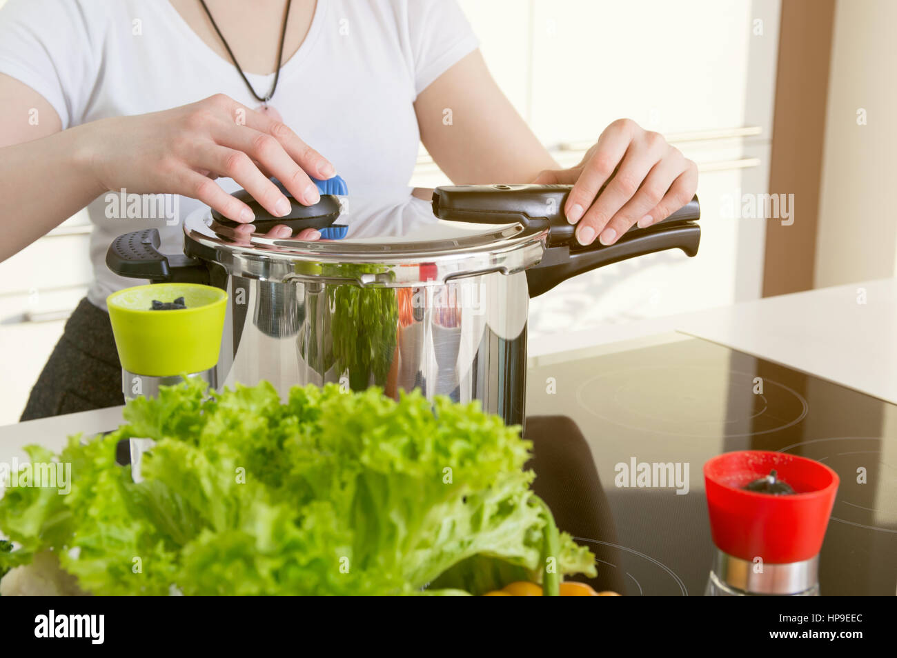 Woman uses pressure cooker to cook a meal. Conception of healthy