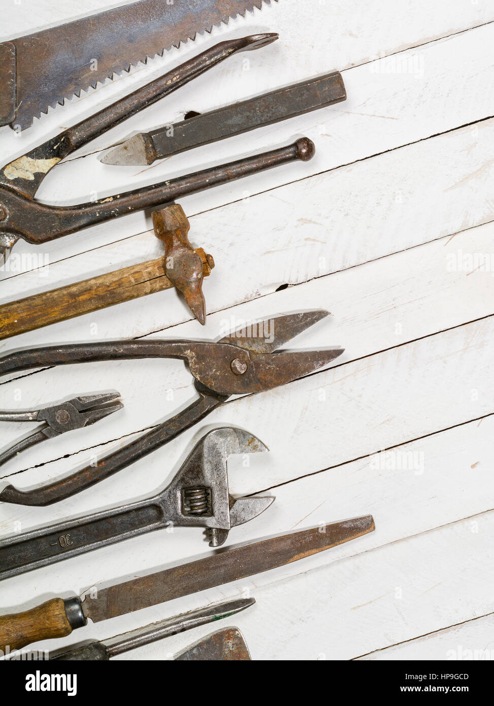 Many old rusty tools scattered on the wooden tstolu. View from above ...