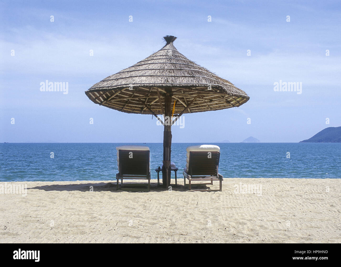 Sonnenschirm aus Schilfrohr, zwei Liegestuehle am Strand, Natrang, Vietnam  Stock Photo - Alamy