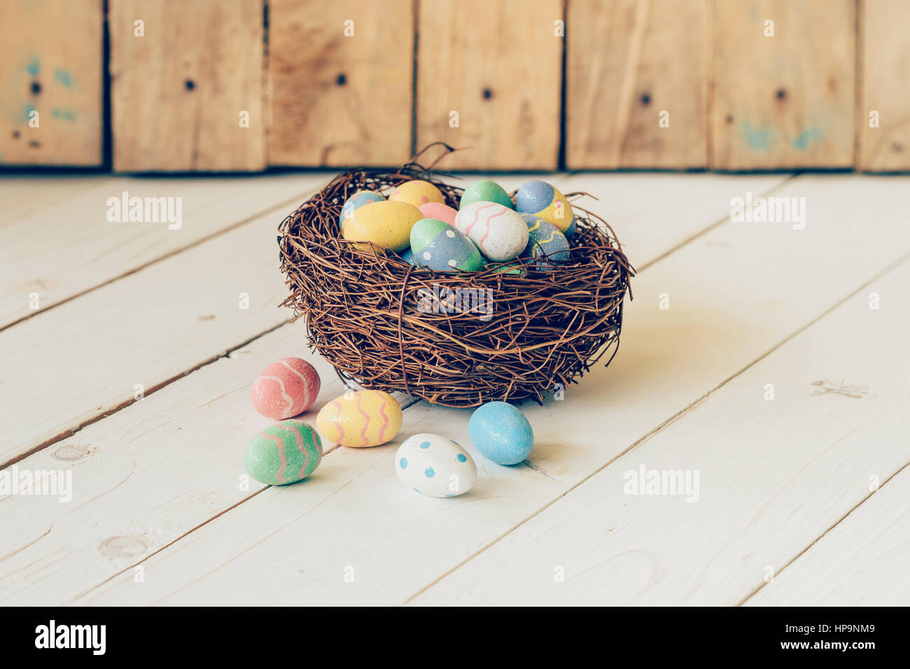 Colorful easter eggs in the nest on wood table background Stock Photo ...