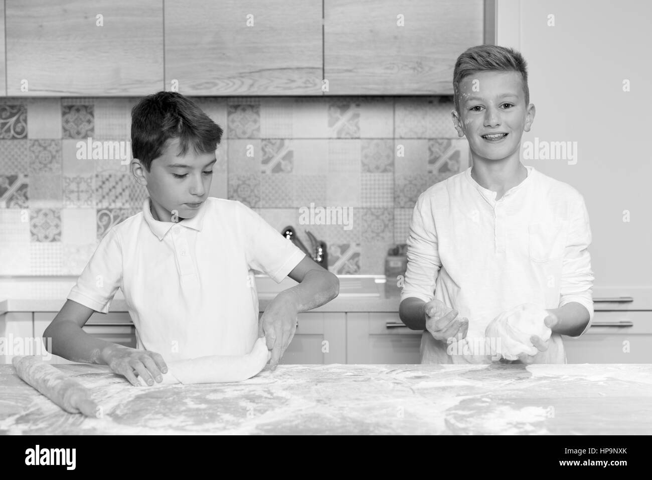 Two children having fun baking in the kitchen, Two brothers playing in kitchen Stock Photo