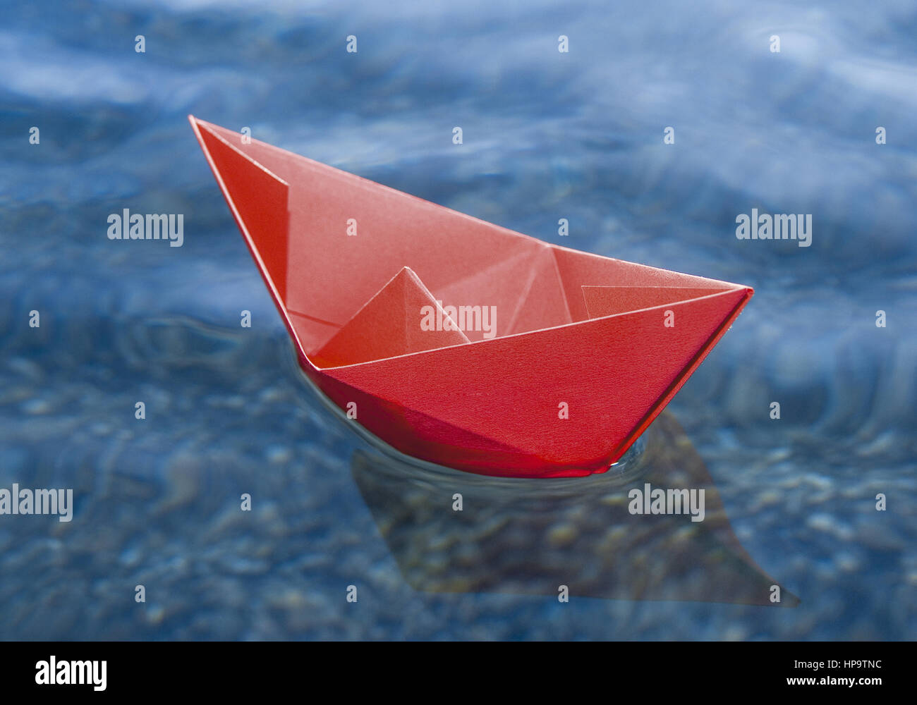 Rotes Papierschiffchen schwimmt auf Wasser Stock Photo