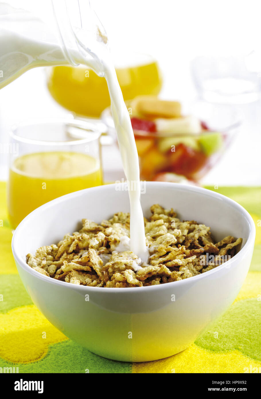 Muesli in Schuessel, Milch wird dazu gegossen Stock Photo