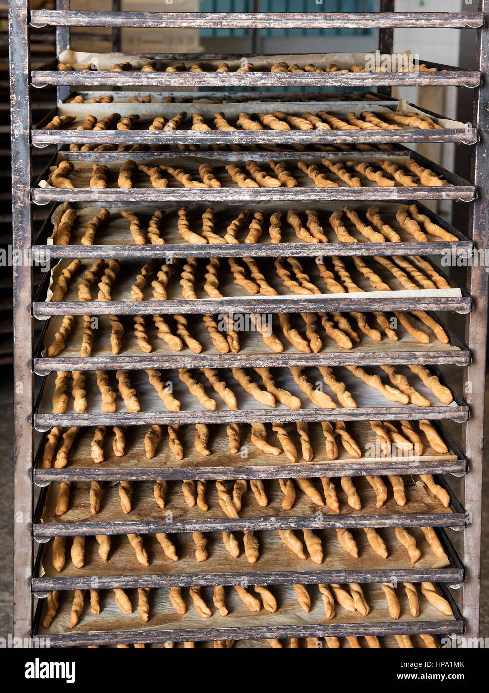 Full frame image of high professional oven with trays full of baked breadsticks in bakery. Bread production background concept Stock Photo