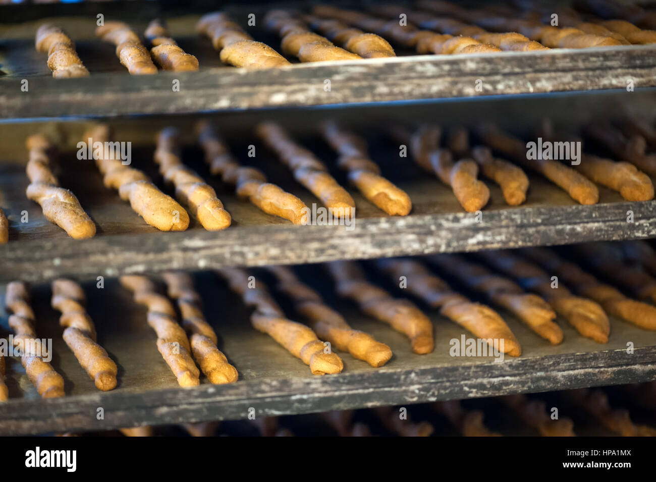 Baking trays with cooked breadsticks cooling in bakery, close-up full frame image Stock Photo