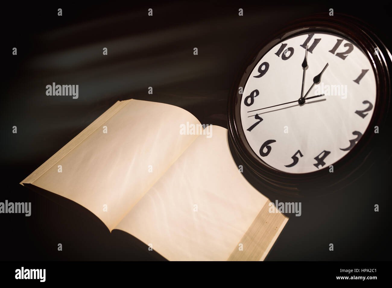 wall clock face and book, concept of time control Stock Photo Alamy