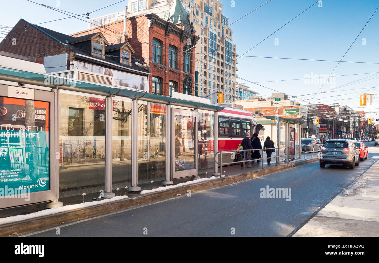 Toronto street scene with streetcar at stop on Queen Stret West in Toronto, Ontario, Canada Stock Photo