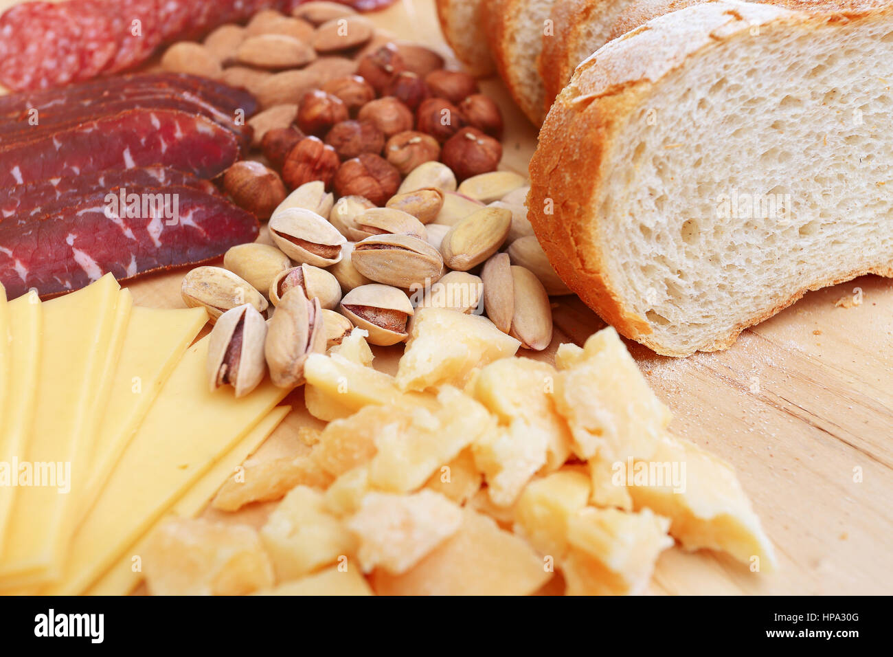 Tasty food background. Bread and cheese on wooden table. Pistachio close-up on wooden board. Stock Photo