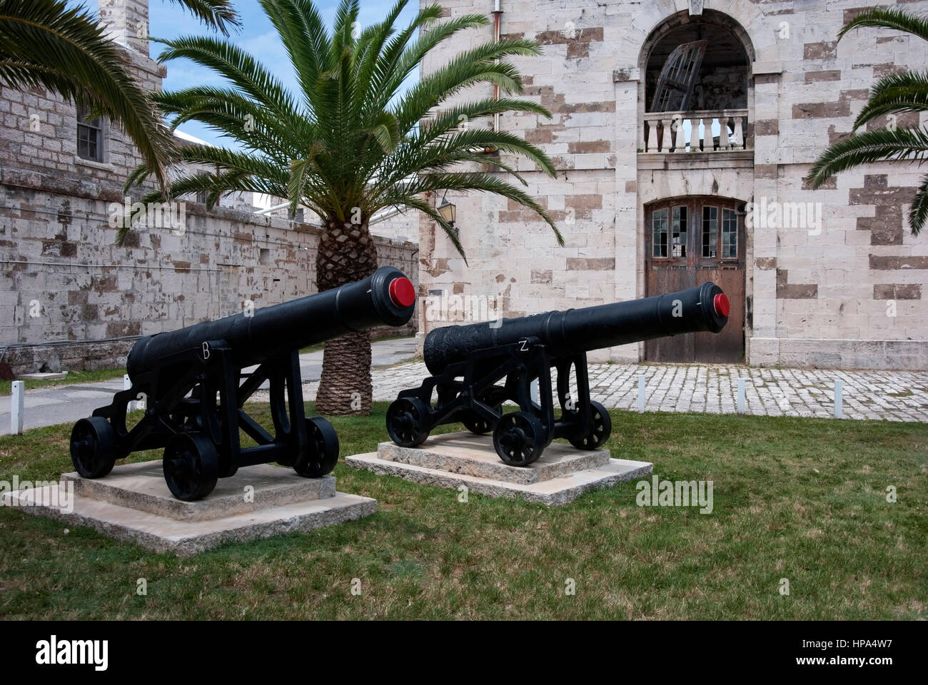 Pair of 18th century Black Cannons on Wheels Museum Exhibits two black former ship ships cannons artillery large gun guns on four wheel wheeled carria Stock Photo