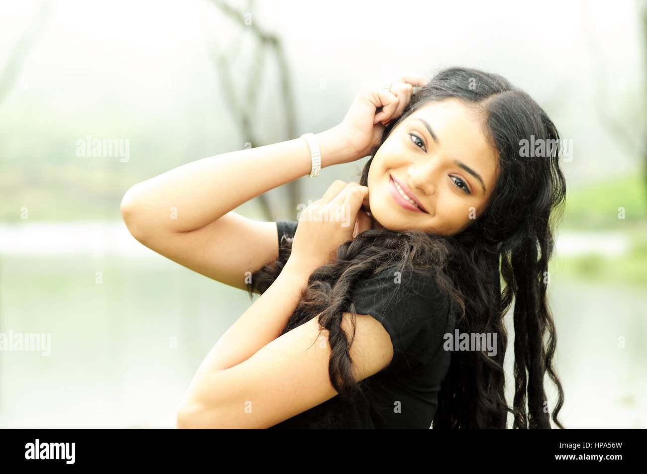 Beautiful young girl posing on river background Stock Photo - Alamy
