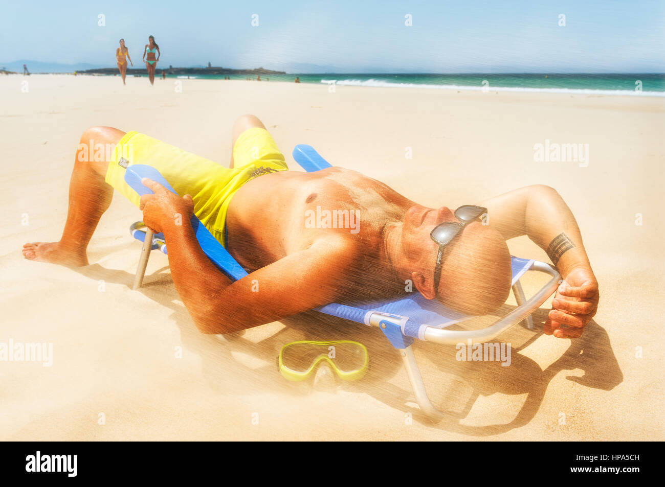 Man at the beach on a windy day. Stock Photo