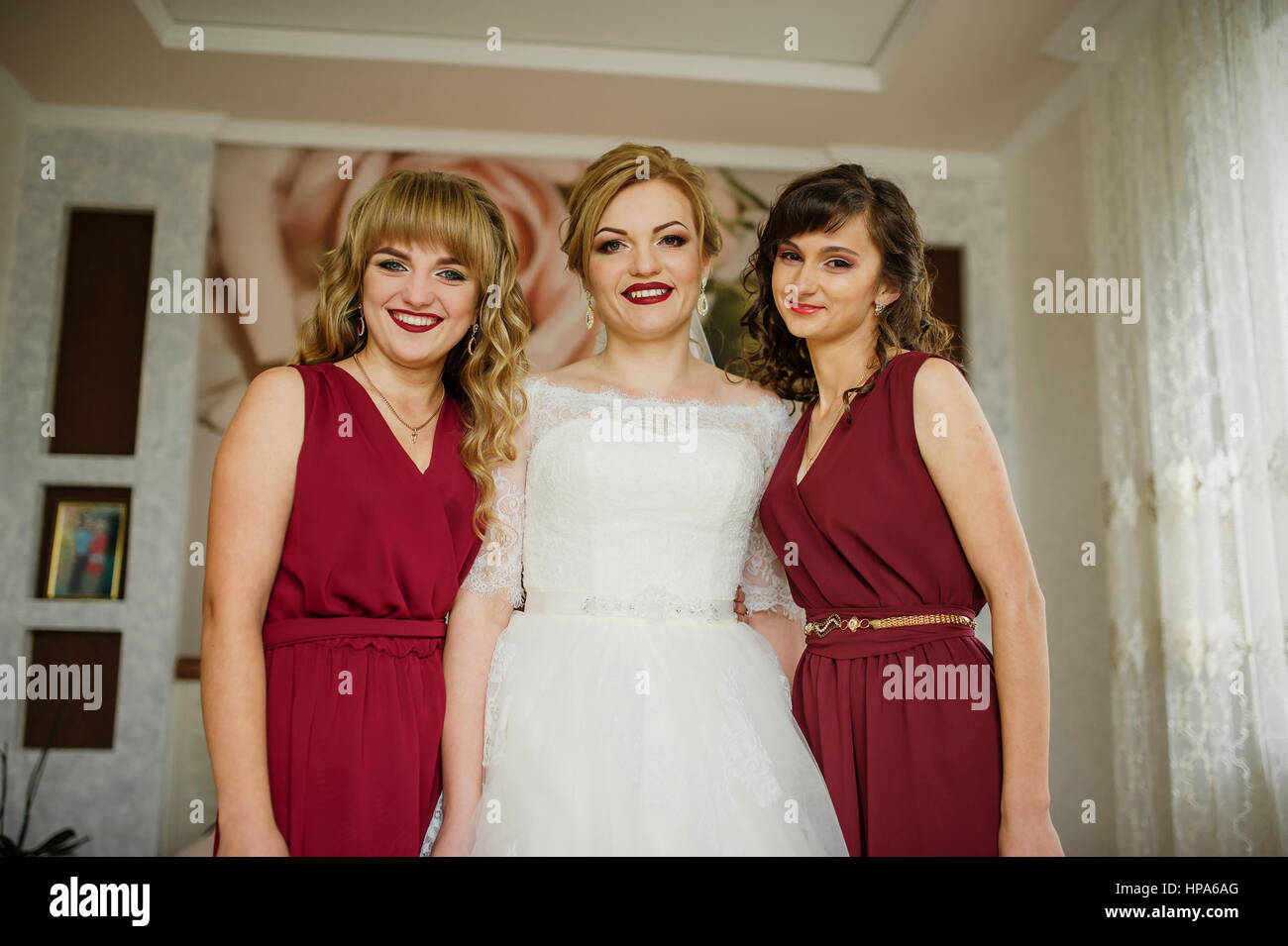 Smilling bride with bridesmaids on red dresses indoor room Stock Photo ...