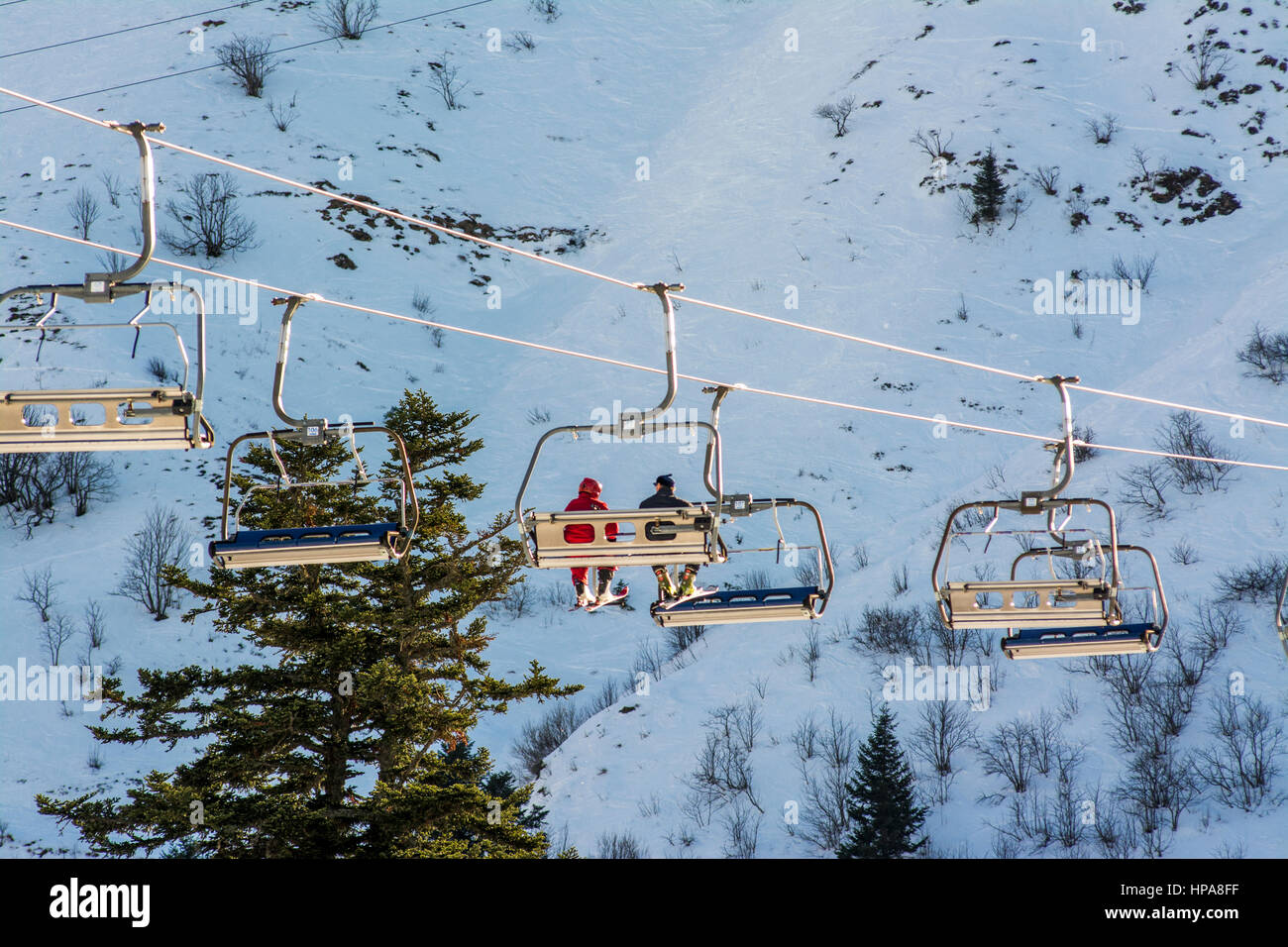 Skiers on a ski lift at Le Mont-Dore ski resort, Massif of Sancy, Auvergne, France Stock Photo