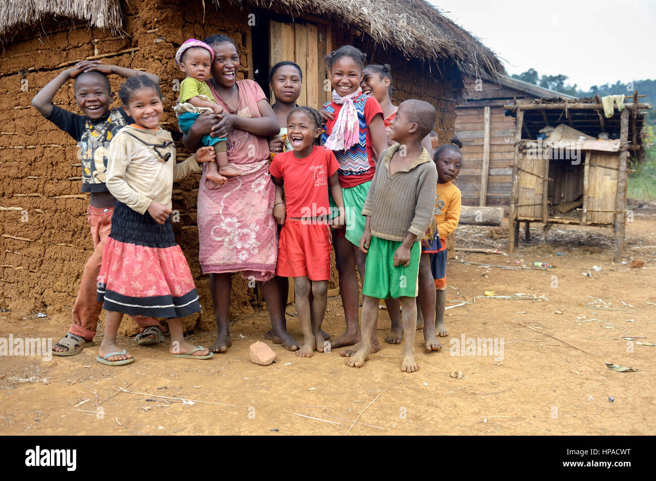 Laughing women and children in front of hut, Berano, Moramanga, Alaotra-Mangoro region, Madagascar Stock Photo
