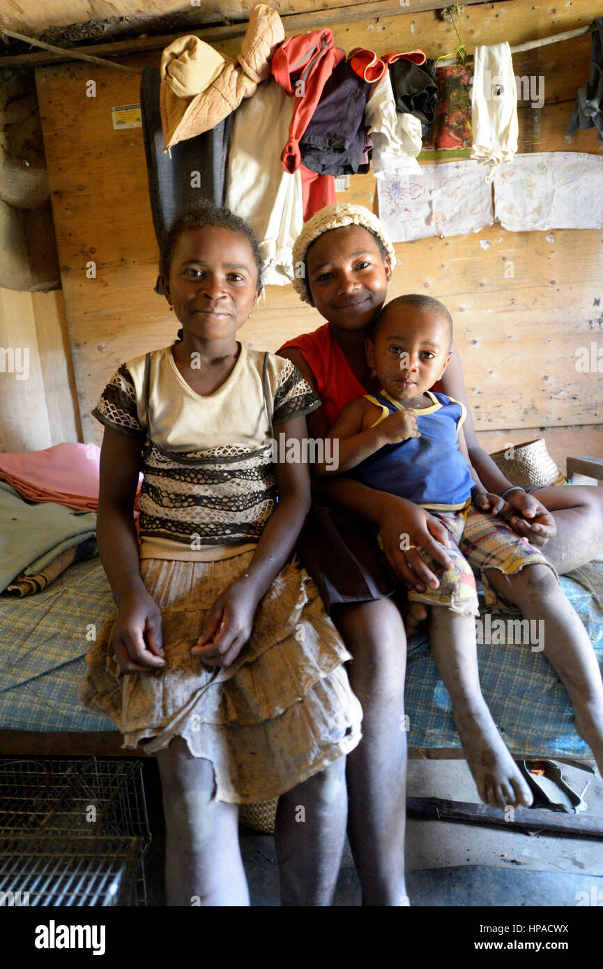 Girls, adolescents and young child in a simple hut, Ambatomainty village, Moramanga, Alaotra-Mangoro region, Madagascar Stock Photo