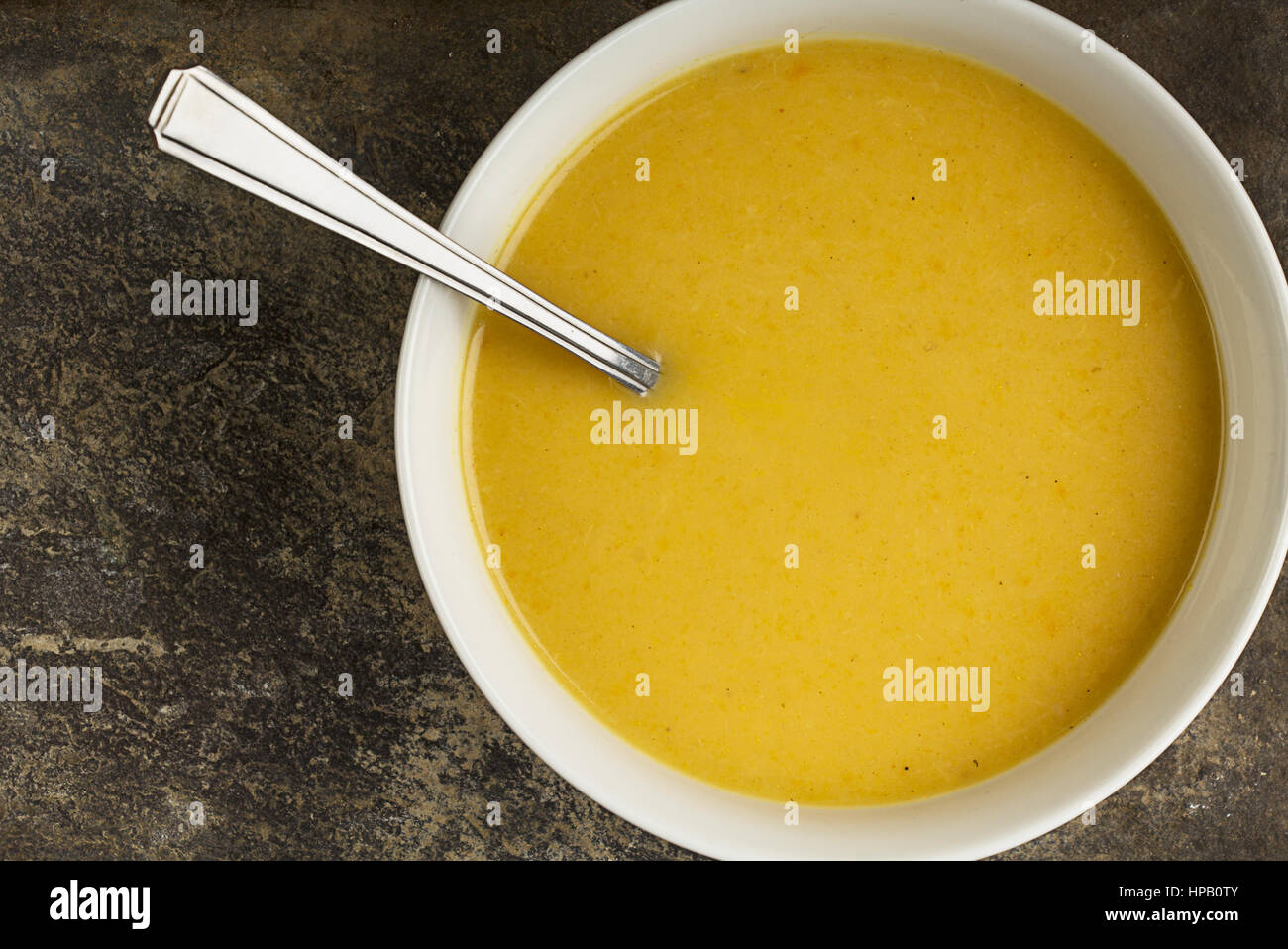 spicy parsnip soup in bowl on plate Stock Photo
