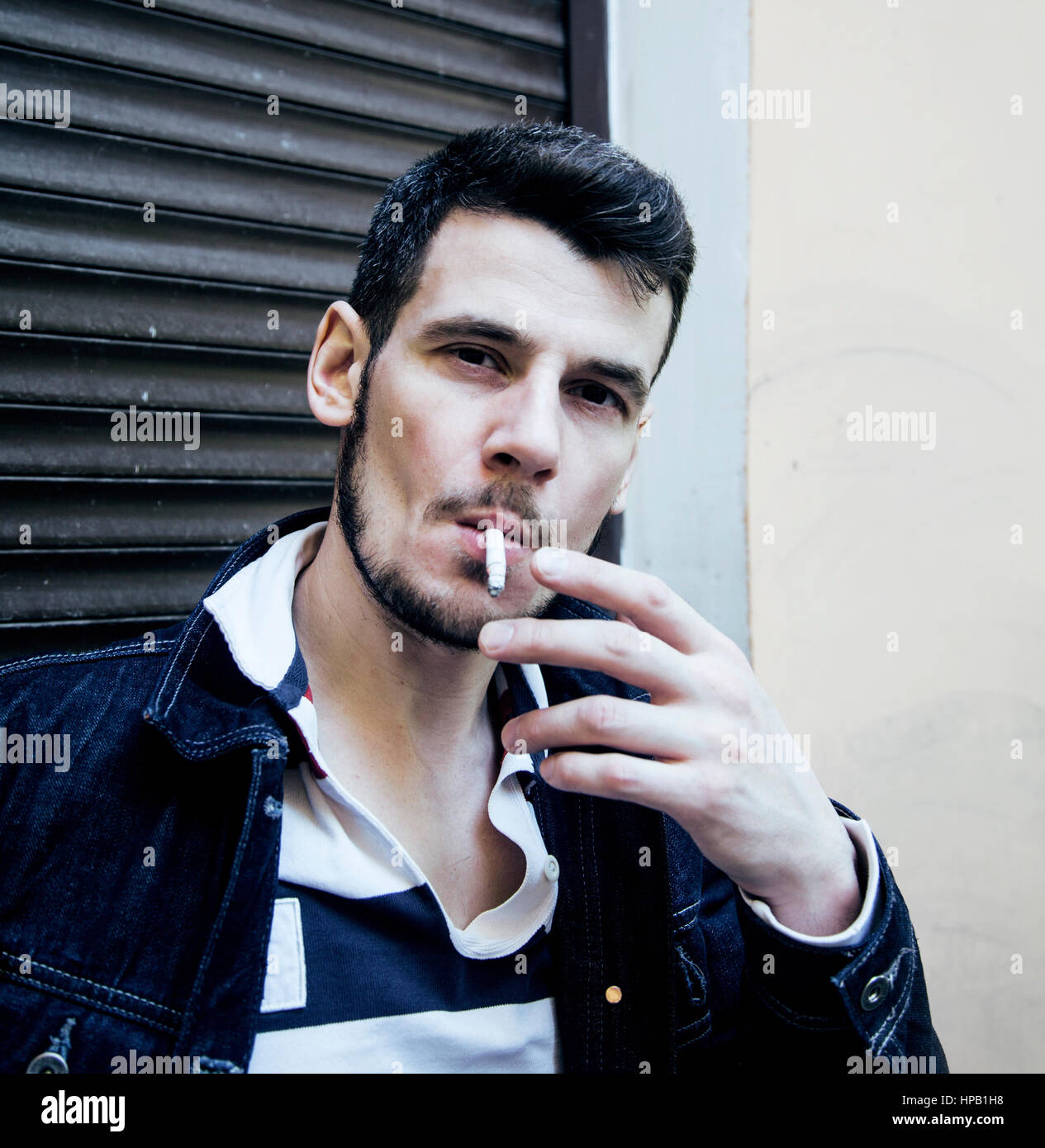 cool guy with cigarette middle age man smoking cigarette on bacyjard, stylish tough guy, lifestyle  people concept close up Stock Photo
