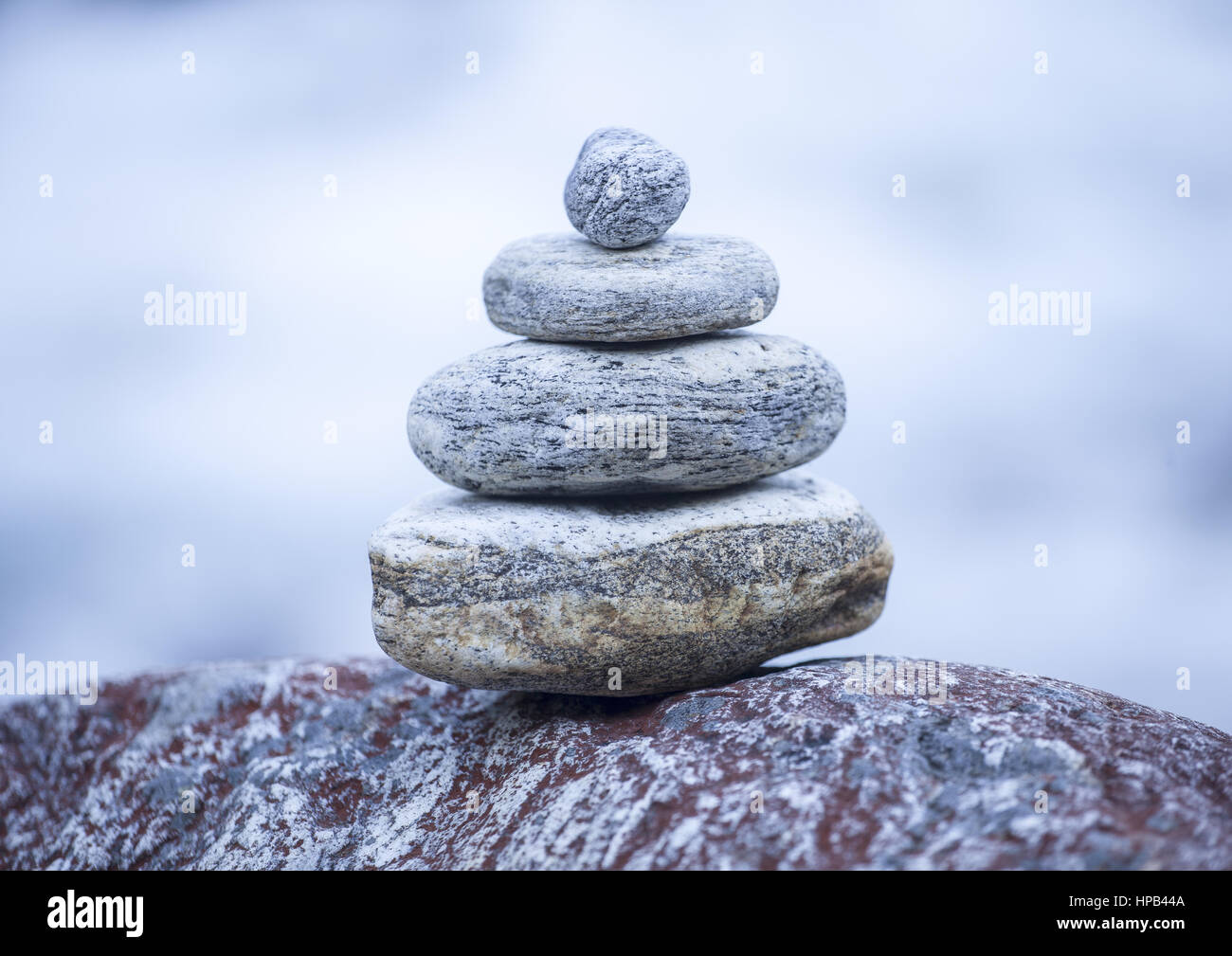 Steinmaennchen mittig vor unscharfem Hintergrund Stock Photo