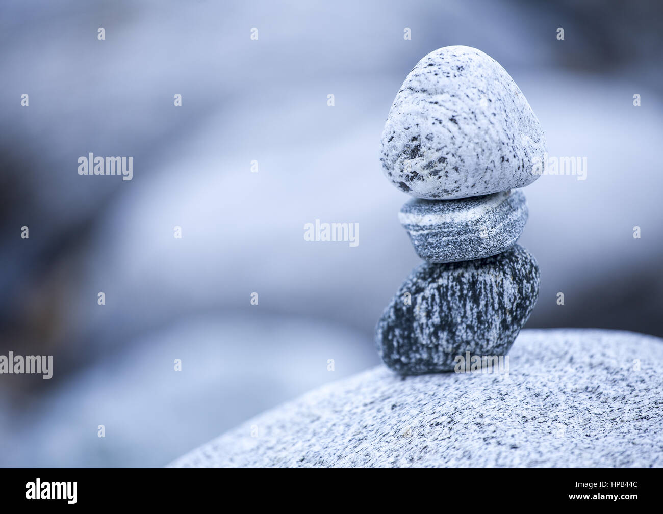 Steinmaennchen vor grauen unscharfem Hintergrund Stock Photo
