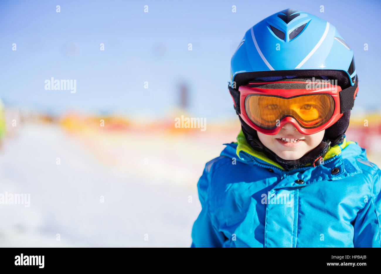 Cheerful young skier wearing safety helmet and goggles Stock Photo