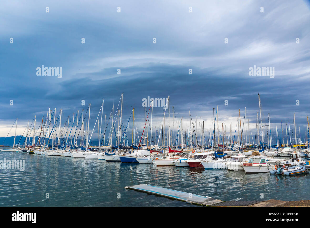 Small fishing and recriational boats docked in the Port of Cagliari, Sardinia, Italy. Overcast cloudy sky on the background Stock Photo