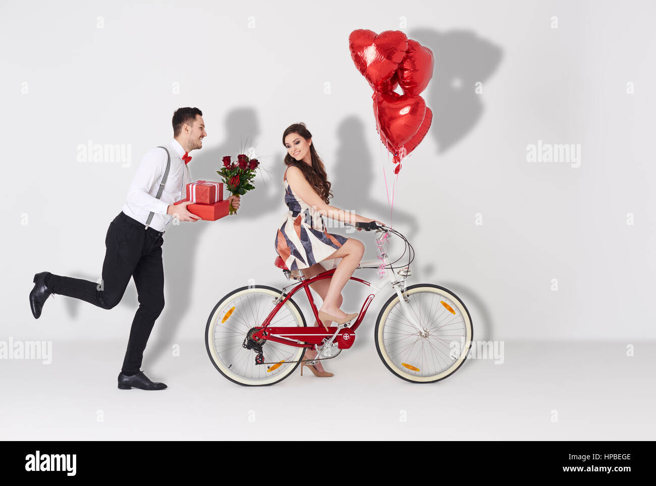 Happy couple with gift and heart shaped balloon Stock Photo - Alamy
