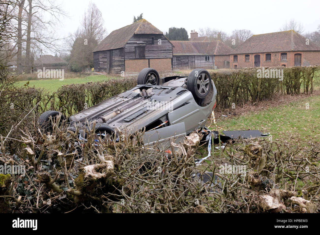 Overturned car landed upside down with police tape in Charlwood near